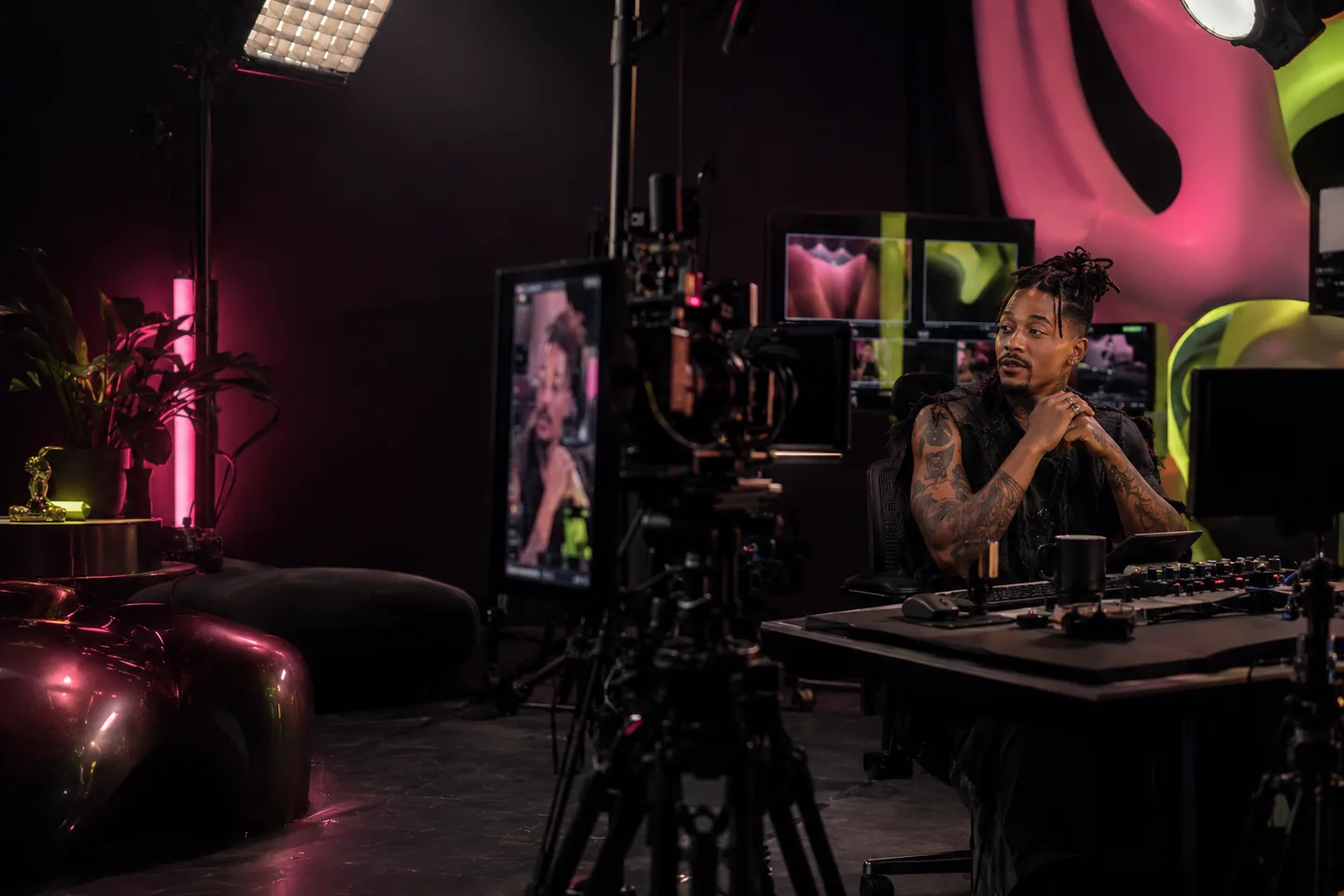 Créateur afrodescendant tatoué dans un studio de live professionnel, entouré de caméras et de la régie